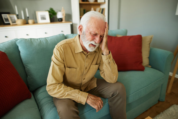 一位老人坐在客厅的沙发上患了偏头痛图片下载
