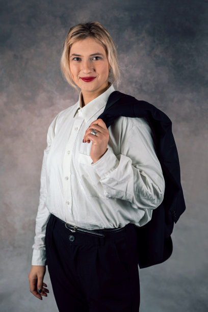年轻的女商人站在一个孤立的单色摄影棚背景上对着镜头微笑图片下载