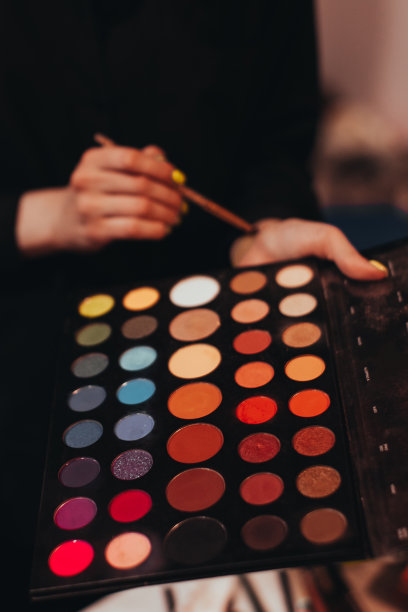 女性手持化妆用的装饰刷和调色板。图片下载