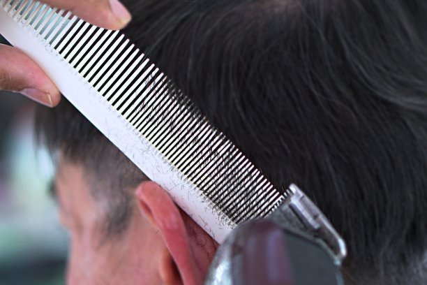 理发师在理发店理发，使用剪刀和梳子。图片下载