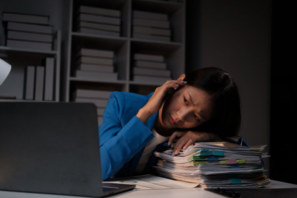 疲惫的亚洲女商人在办公室兼职，独自一人在办公室工作图片下载