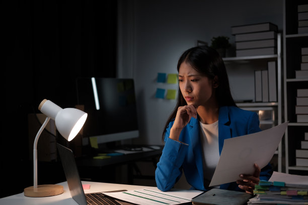 疲惫的亚洲女商人在办公室兼职，独自一人在办公室工作图片下载