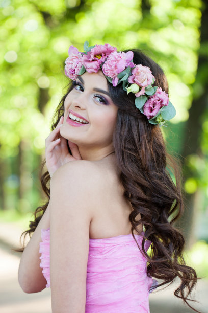 快乐的夏天女人肖像。春天美女模特在粉红色的花圈上微笑图片下载