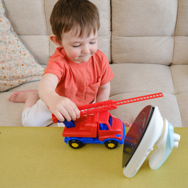 婴儿的行为很危险，因为他们在客厅里玩热熨斗。没有大人的监督，孩子很容易被烧伤。两岁左右(一岁十个月)图片下载