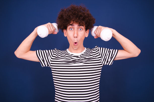 滑稽的家伙在用哑铃健身。图片下载