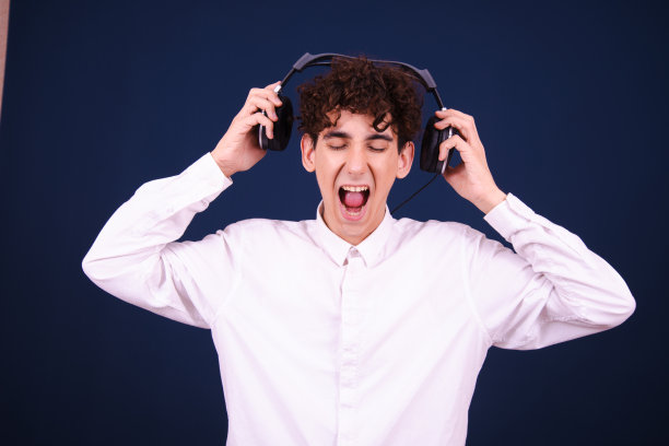 周末。风趣情绪化的家伙戴着耳机听音乐。图片下载