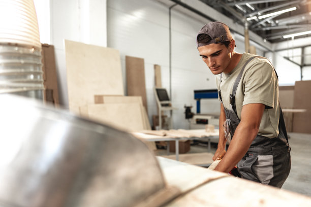 男木匠在工厂里使用木工工具图片下载