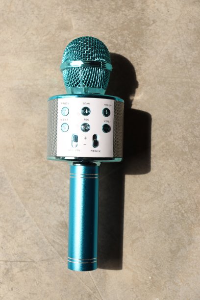 一个蓝色闪亮的金属无线麦克风和扬声器装置，在水泥地板上有按钮图片下载
