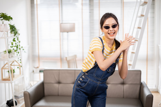 亚洲年轻美女飘带听音乐跳舞和听音乐在家庭室内，住宅大楼。在社交媒体应用tiktok上分享视频图片下载