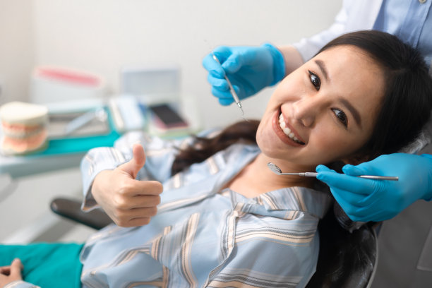 医疗保健和医药概念。快乐的亚洲妇女看着镜头和参观牙医办公室。图片下载