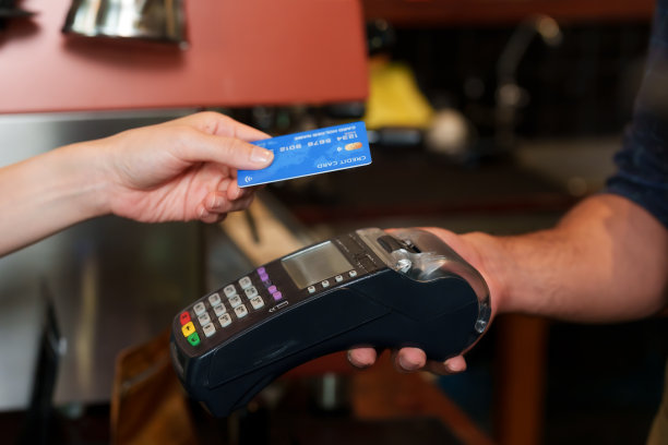 近距离的顾客用带有数据读取系统的信用卡用信用卡读卡器支付咖啡和面包。尽量减少接触，没有现金支付。旅行时的咖啡馆图片下载