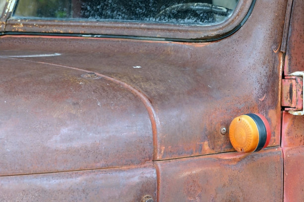 一辆锈迹斑斑的旧车转向灯的侧视图。图片下载