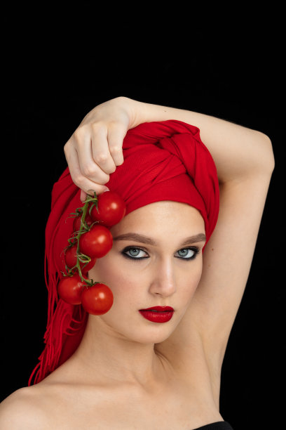 美丽的特写肖像的年轻女子与番茄。健康食品和蔬菜的概念。护肤美容。维生素和矿物质图片下载