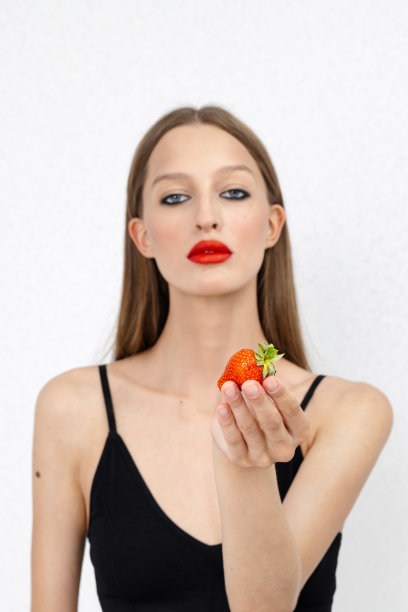 照片中，美女手持红草莓图片下载