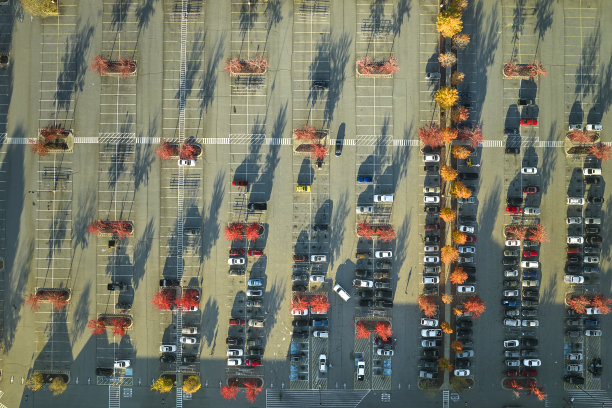 从上面看到停车场上许多停放的汽车，上面有停车位置和方向的线条和标记。在一个购物中心前停放车辆的地方图片下载