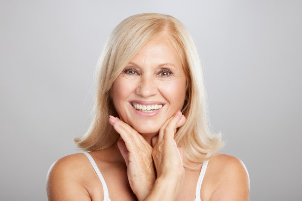 美丽的金发高级女子的肖像摆姿势，看着相机。美摄影图片下载