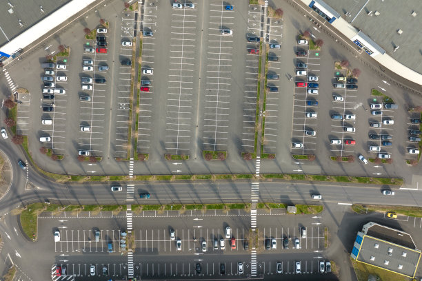 许多彩色汽车停在停车场的鸟瞰图，有线条和停车位置和方向标记图片下载