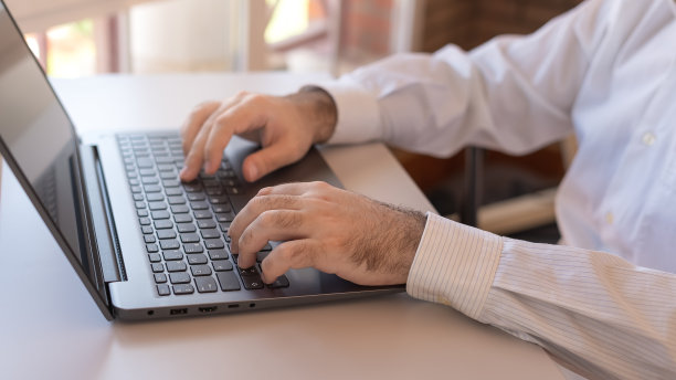 男人在笔记本电脑上打字，在家远程办公。图片下载