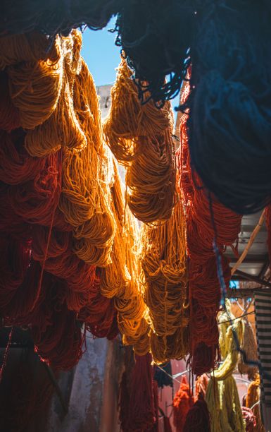 在一个城市的市场上，五颜六色的纱线挂在钩子上图片下载