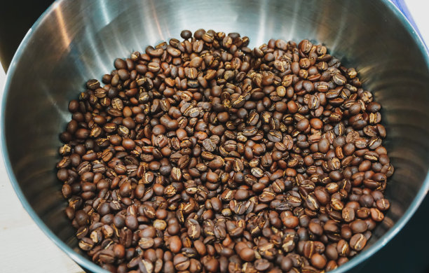 在不锈钢碗中烘烤棕色咖啡豆。香味浓郁的咖啡豆是经烘焙而成，热香咖啡又有机新鲜，焙烤咖啡业熟制而成。图片下载