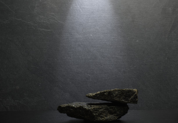 深灰色背景上的黑色石头作为产品展示的讲台背景。图片下载
