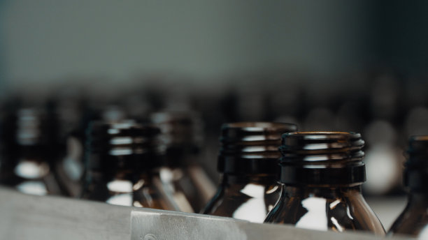 传送带与空的医用注射玻璃小瓶。玻璃管在传送带上运行。没有标签的透明瓶子在实验室的药品传送带上移动图片下载