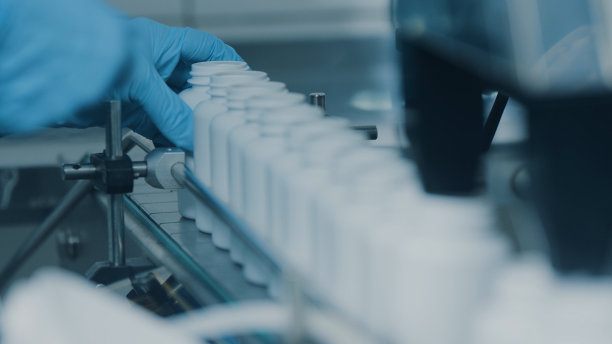 4K输送机，在生产线上移动白色的空塑料管，并填充胶囊。工厂里的自动机器。现代高科技药物厂。特写，DOF图片下载