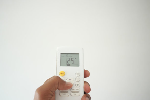 男子手持空调遥控器的特写。图片下载