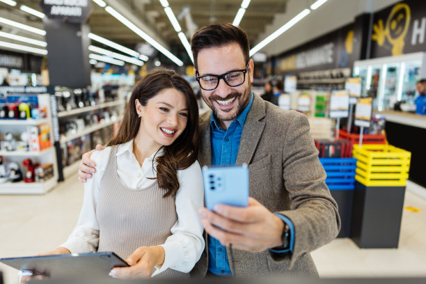 年轻夫妇在现代科技商店买东西。图片下载