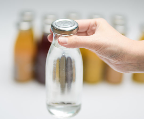 手里拿着带饮用水的玻璃瓶图片下载