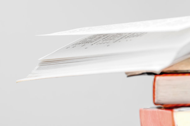 图书馆里的一堆书，其中一本打开在上面，五颜六色的书脊。教育的概念。图片下载