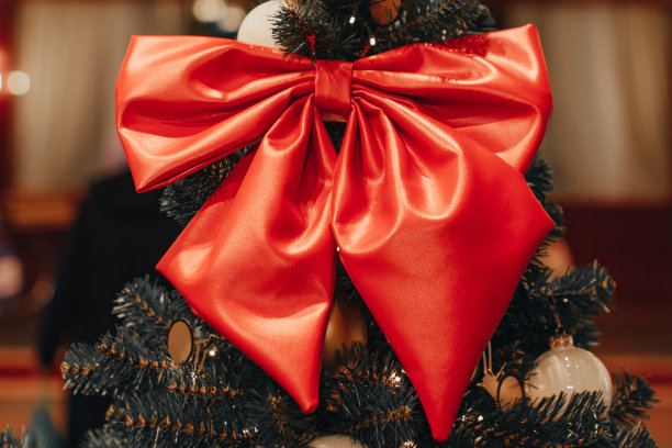 圣诞树上挂着喜庆的红色蝴蝶结。美丽的新年装饰。图片下载