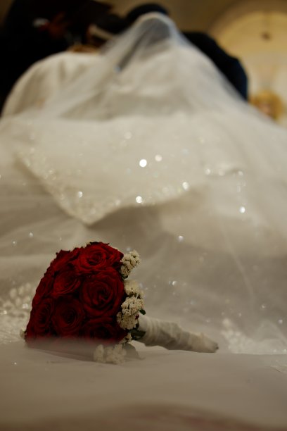 婚礼当天新娘礼服上的红色玫瑰花束图片下载