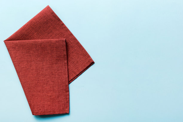 顶视图与红色空厨房餐巾孤立在桌子背景。折叠布料与复制空间的模型，平铺。最小的风格图片下载