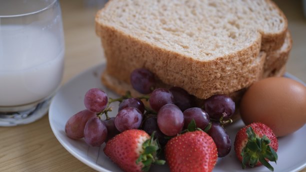 早餐有烤面包、新鲜水果和一杯牛奶。图片下载