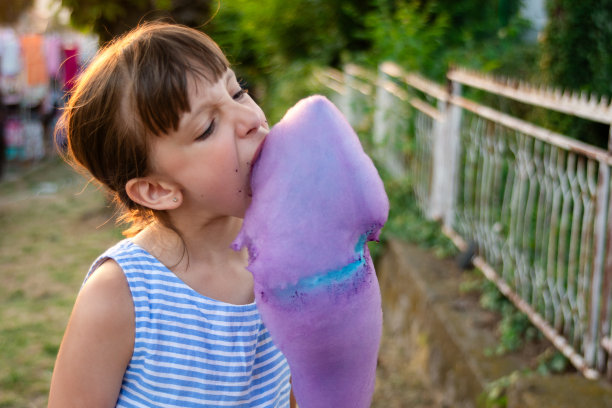 在集市上吃棉花糖的女孩图片下载