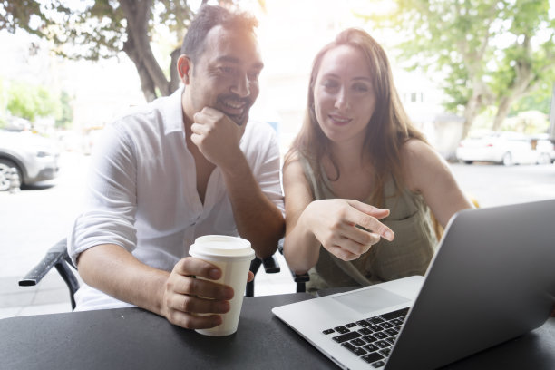 幸福的情侣坐在咖啡馆里用笔记本电脑上网图片下载
