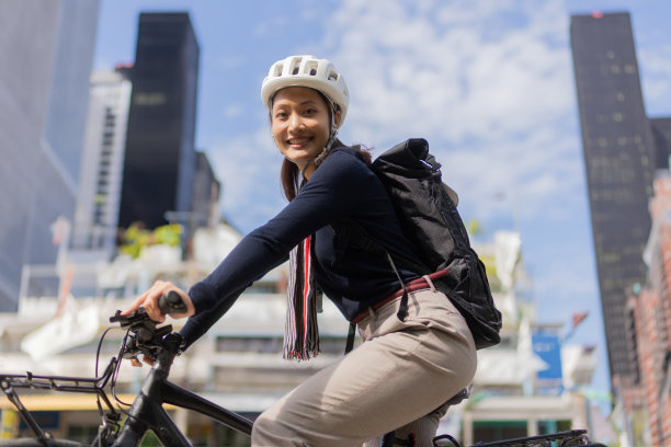 天气好的时候，一个亚洲女人骑着自行车去上班图片下载