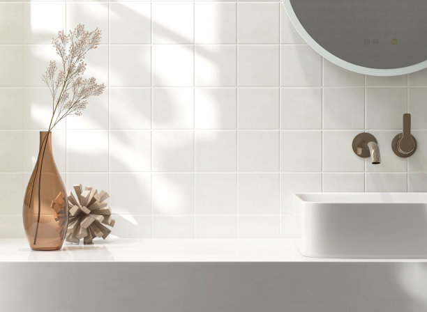 白色的梳妆台面，方形的墙砖配陶瓷面盆，现代简约风格的水龙头，浴室里的花瓶在清晨的阳光和阴影中图片下载