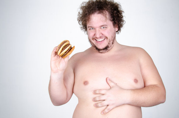 饮食和健康的生活方式。吃汉堡的滑稽胖子。图片下载