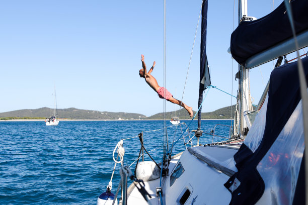 一个人从帆船上跳入大海，从船上眺望图片下载