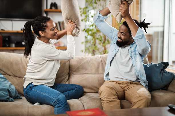 一对快乐的黑人夫妇在家里玩枕头图片下载