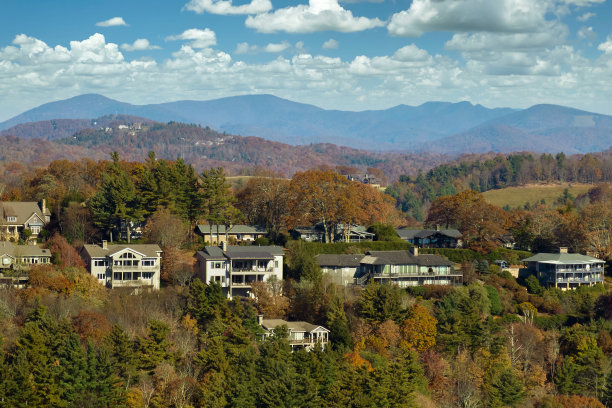 鸟瞰北卡罗莱纳州郊区秋天黄色树木之间山顶上的大型家庭房屋。美国郊区的房地产开发图片下载