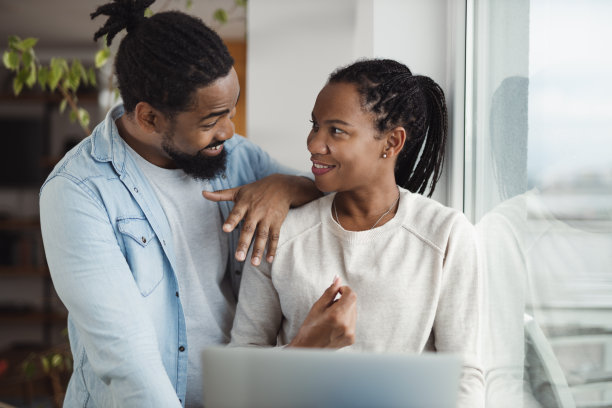 年轻的黑人夫妇边说边用笔记本电脑图片下载