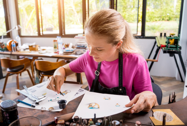 年轻的女珠宝商在车间制作珠宝图片下载