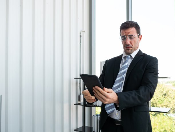 一位白人商人在办公室公司的平板电脑屏幕上阅读和展望营销解决方案规划图片下载