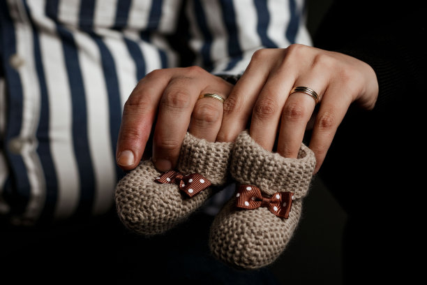 父母手握针织婴儿袜的特写镜头图片下载