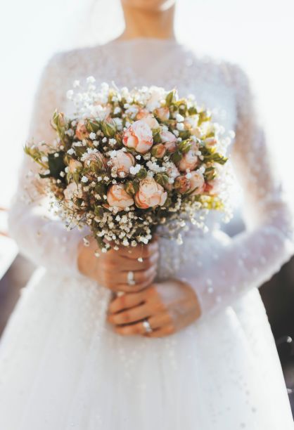 新娘手持婚礼花束，身穿白色婚纱图片下载