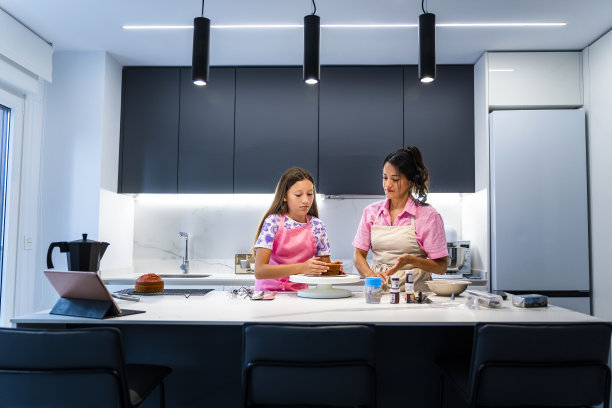 母亲和女儿在现代厨房里做蛋糕图片下载