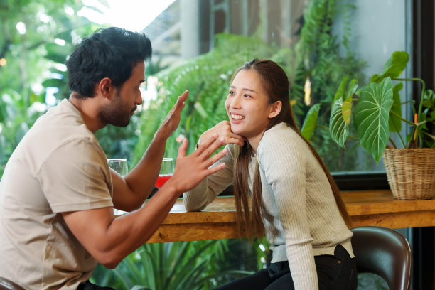 美丽的亚洲夫妇和印度男人坐在咖啡馆里放松，在咖啡馆的窗口喝着酒，开心地聊天，在一天的闲暇和休息图片下载